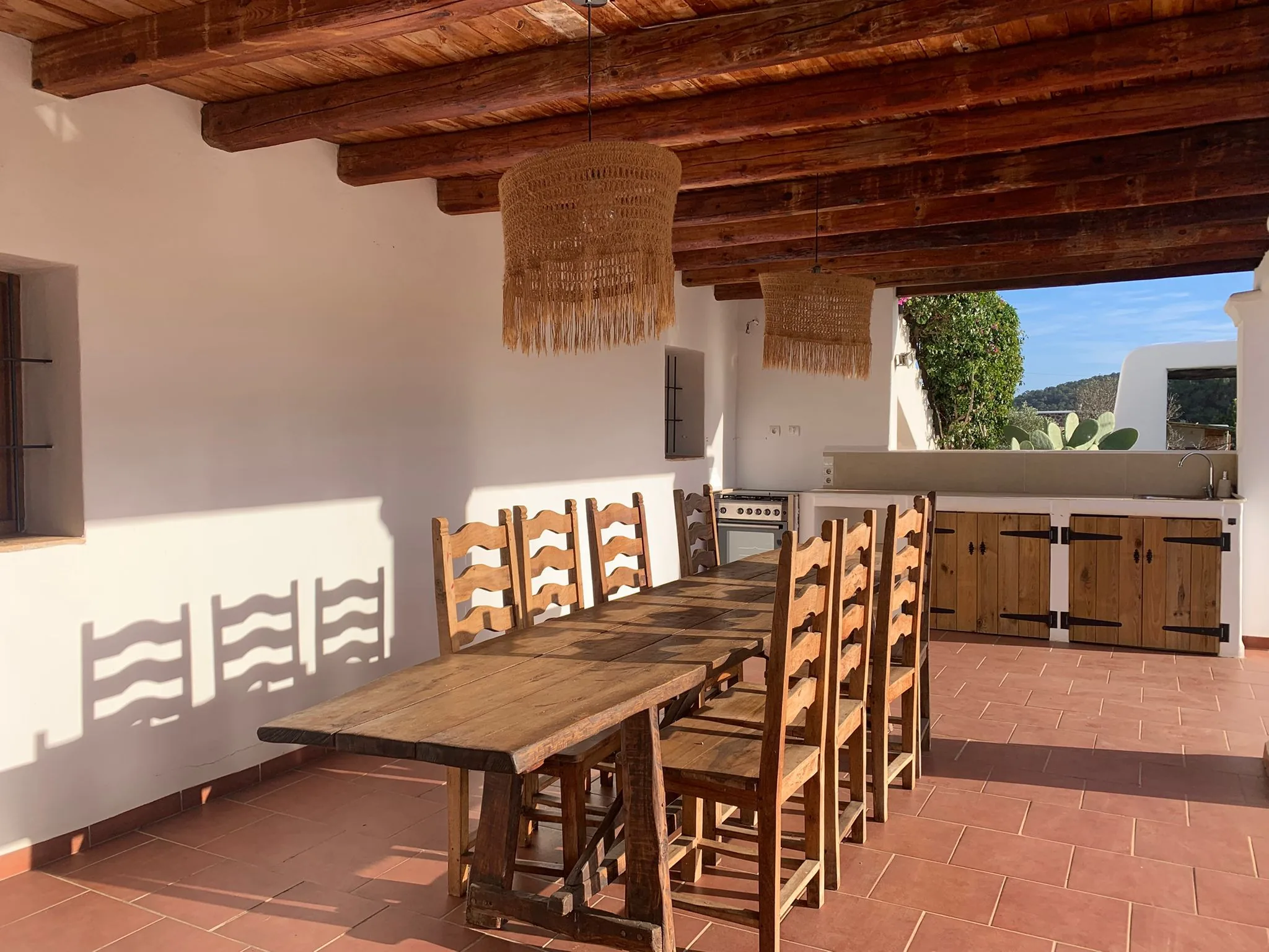 Covered outdoor dining terrace with rustic wooden table — La Casa de Mis Sueños