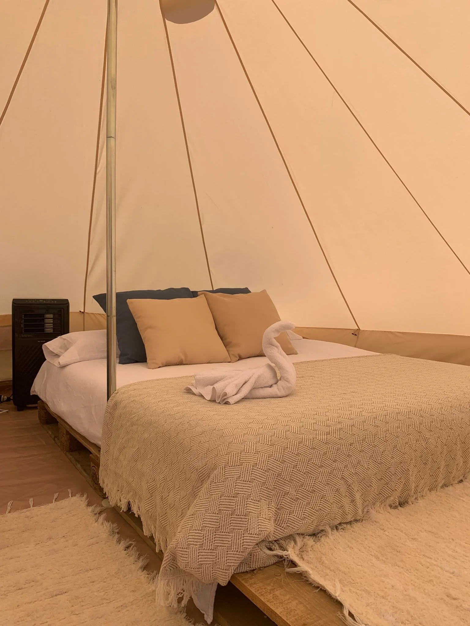 Glamping tent bed with swan towel art — boutique glamping Ibiza