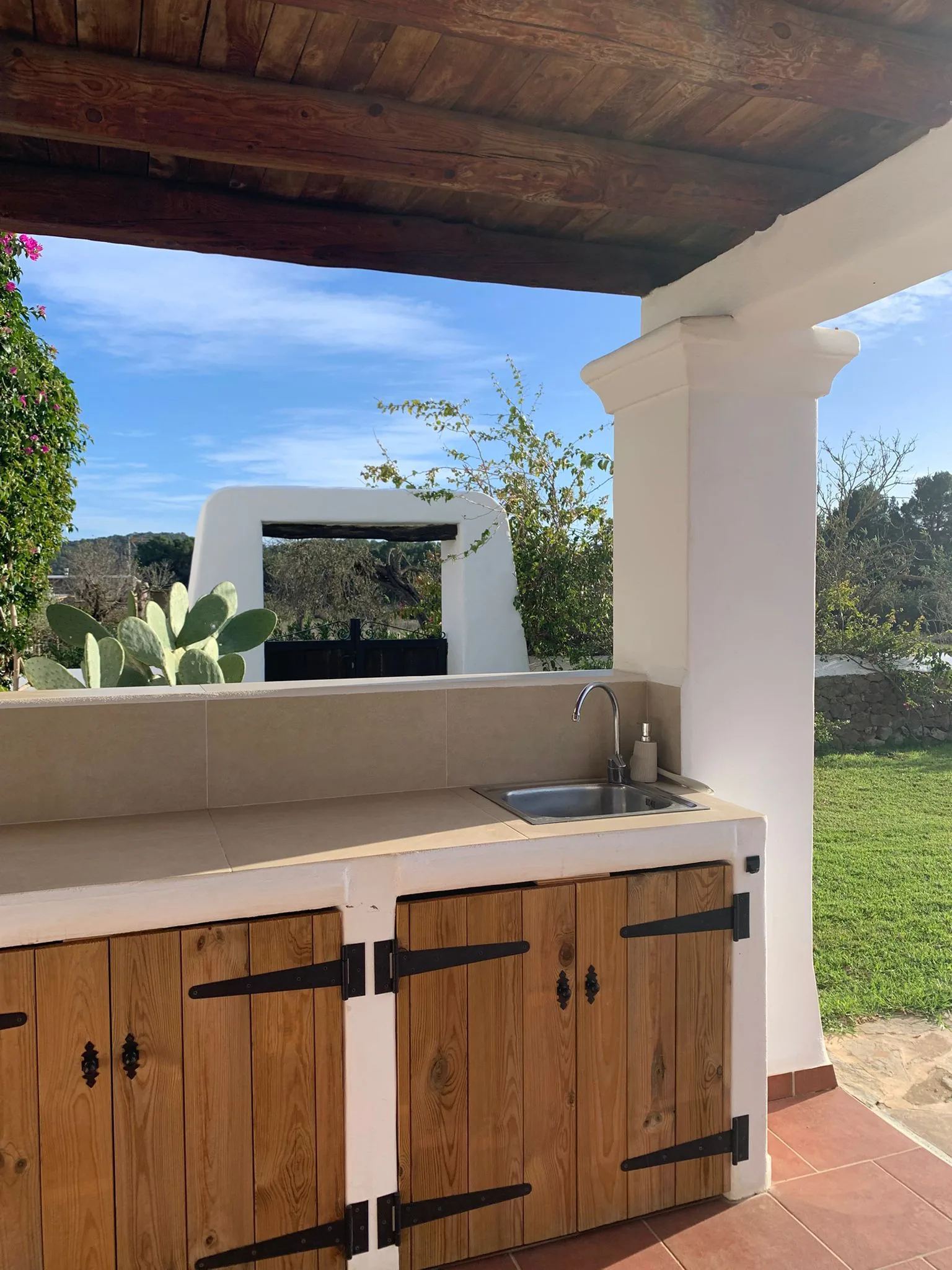 Outdoor kitchen and bar area under the portico — communal space at the finca