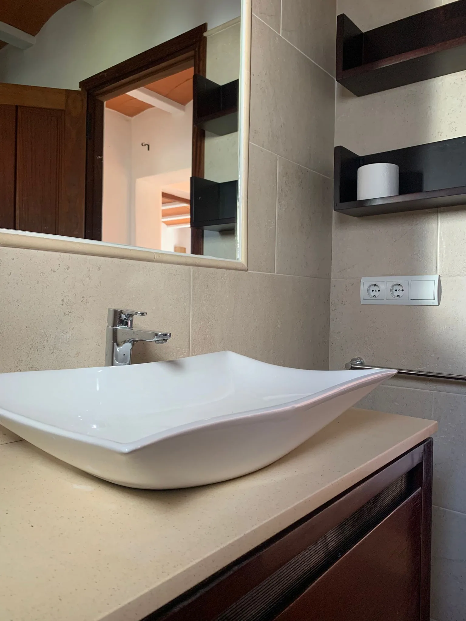Modern private bathroom with design vessel sink and natural stone tiles