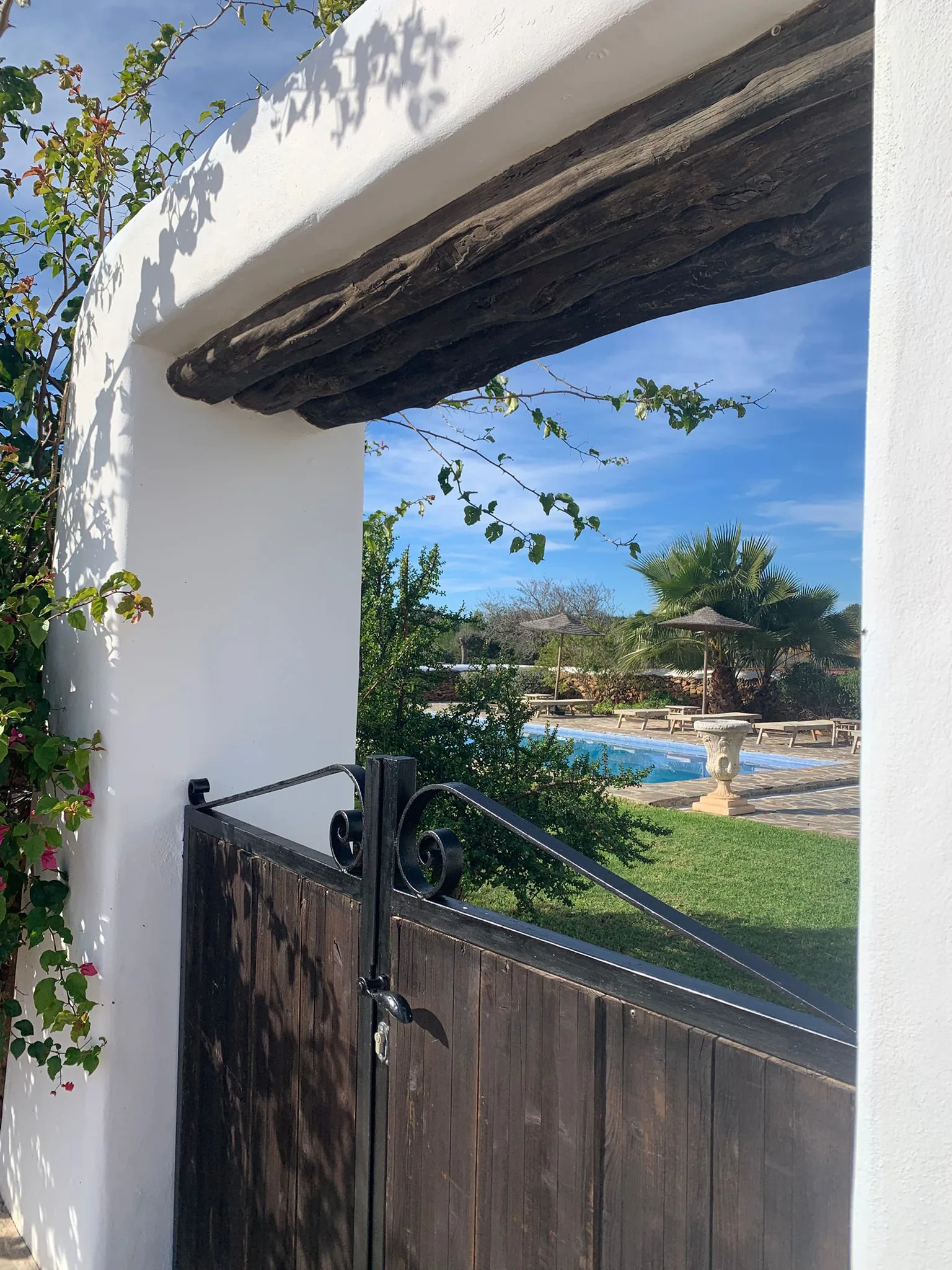 Iron gate opening onto the pool garden at La Casa de Mis Sueños
