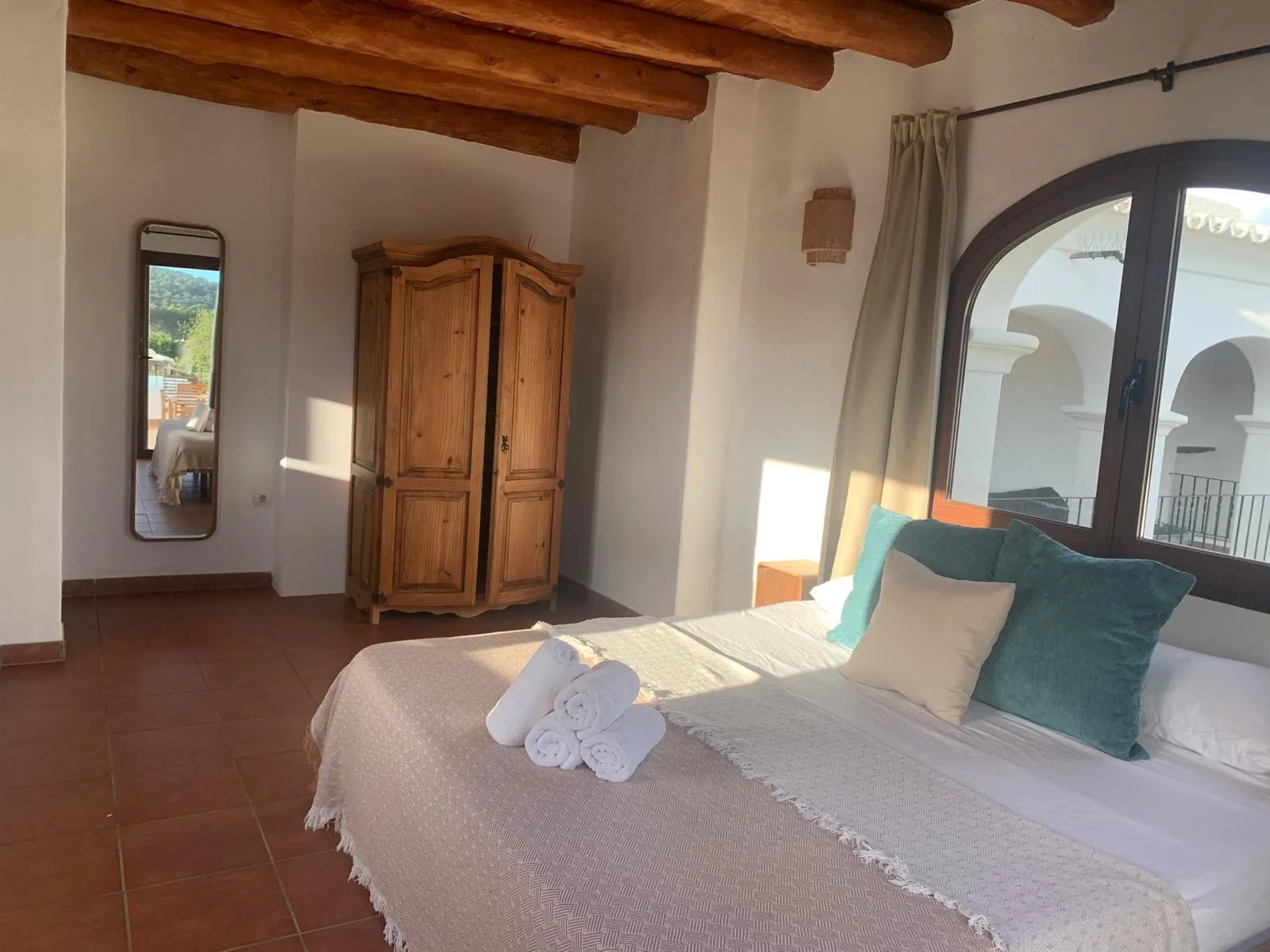 Finca bedroom with wooden beam ceiling and built-in wardrobe